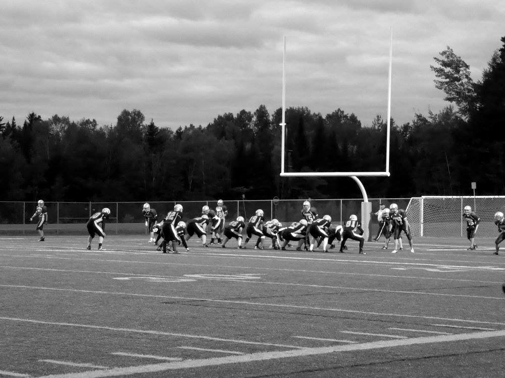The Black Kats line up on the field before a game, viewed from the sideline